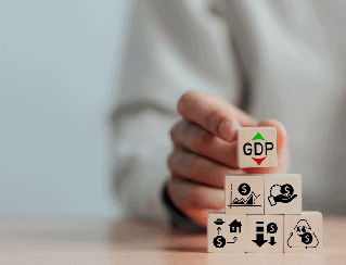 Hand stacking a block labeled GDP on top of a stack of economic blocks, illustrating GDP as the foundation of the economy.