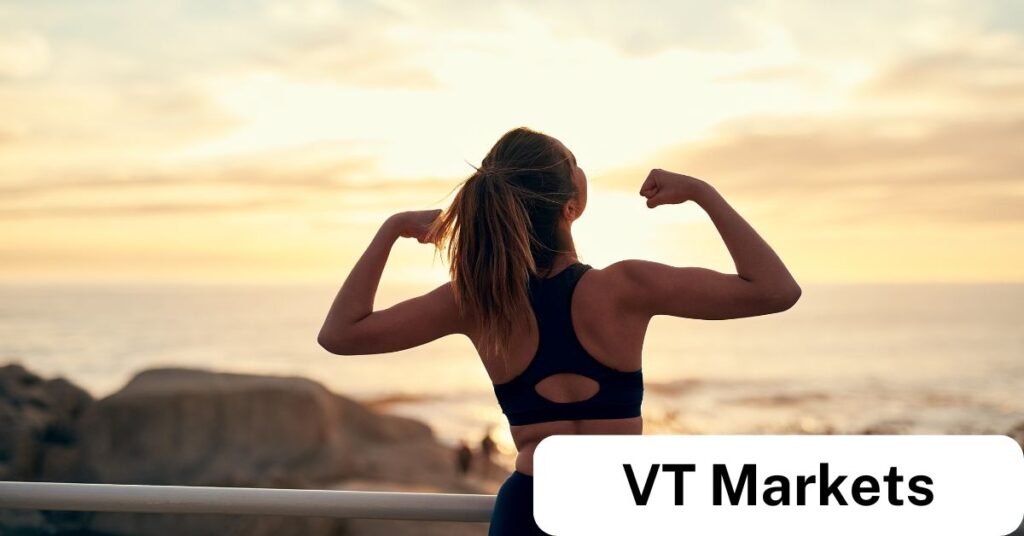 Woman flexing her arms at sunrise, symbolising strength, discipline, and confidence—key traits for building a profitable trading routine with VT Markets.